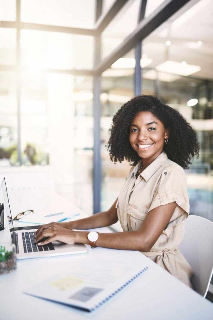 portrait of black woman with laptop, admin and typing report with paperwork at desk