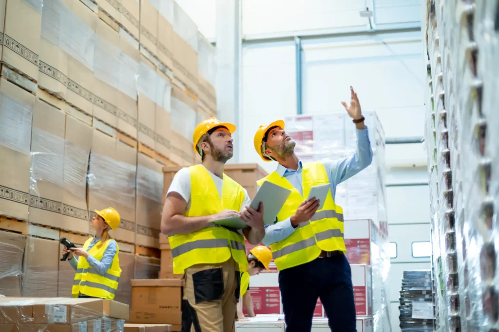Warehouse workers looking on documents and checking list of packages